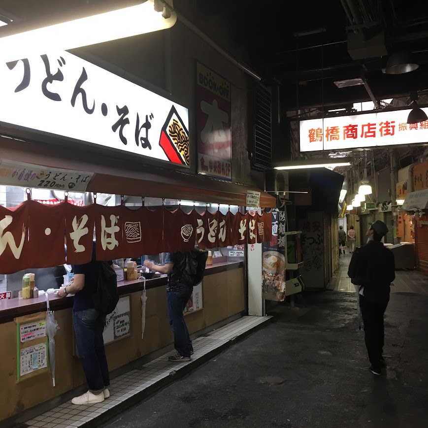 鶴橋の商店街に並ぶお店と通りを歩く人